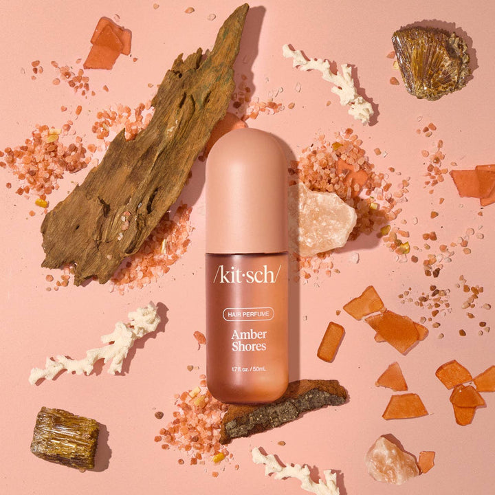 Parfum pour cheveux KITSCH Amber Shores 50 ml avec vaporisateur ouvert, flacon rose poudré mat sur fond beige minimaliste, photo produit professionnelle.