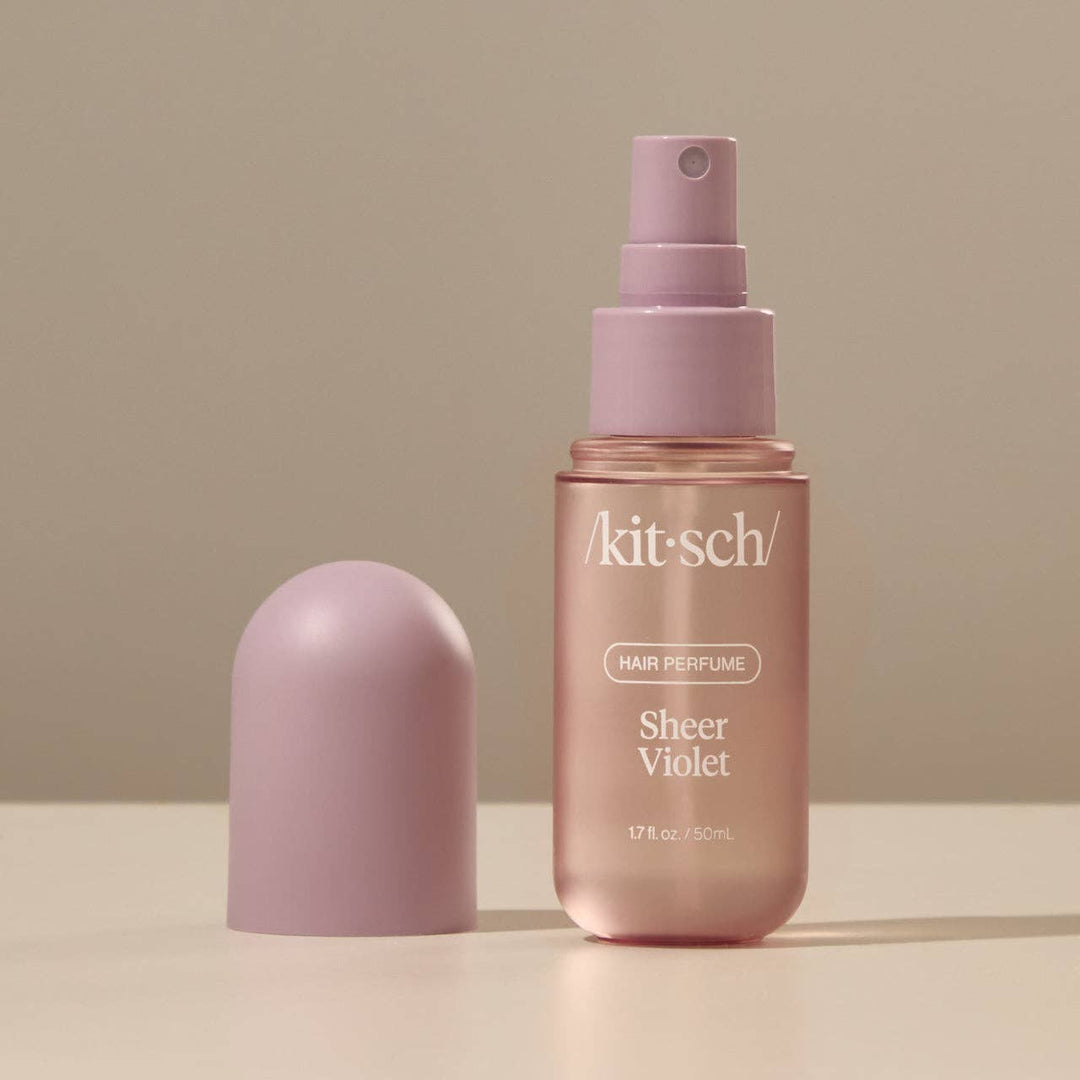 Flacon de parfum pour cheveux KITSCH Sheer Violet accompagné des notes de framboise, violette, iris italien et muscs doux, sur fond minimaliste.