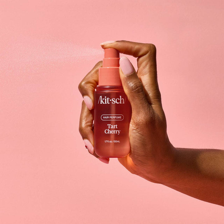 Main vaporisant le parfum pour cheveux KITSCH Cerise Acidulée 50 ml. Brume légère parfumée idéale pour rafraîchir les cheveux entre deux shampoings.