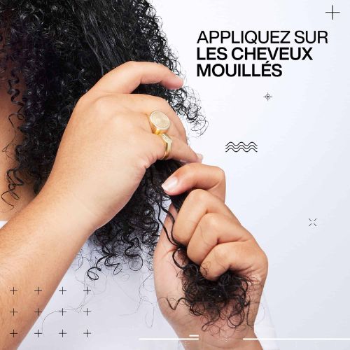 Main appliquant un gel coiffant sur cheveux bouclés mouillés pour définir les boucles avec texte appliquez sur les cheveux mouillés.