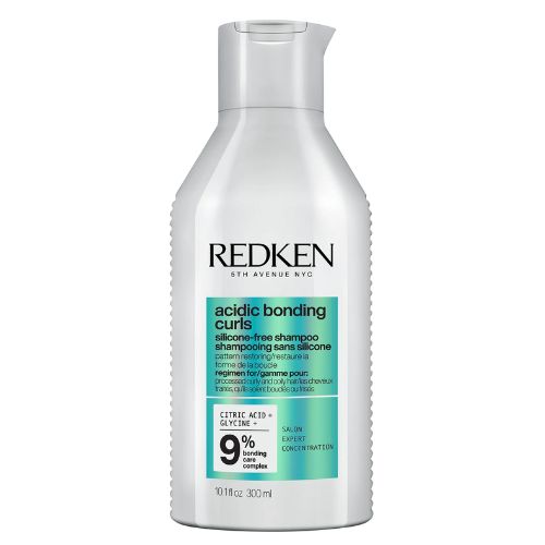 Flacon REDKEN Acidic Bonding Curls shampoing 300 ml gris clair avec étiquette turquoise pour cheveux bouclés sur fond blanc.