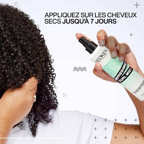 Main vaporisant REDKEN Refreshing Curl Mist sur cheveux bouclés secs pour rafraîchir et redéfinir les boucles.