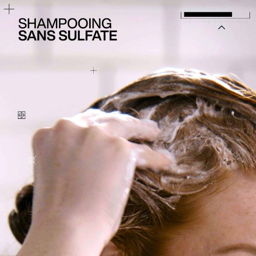 Main massant un shampoing mousseux dans les cheveux avec texte shampoing sans sulfate.