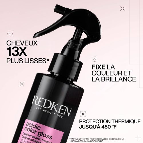 Bouteille REDKEN Acidic Color Gloss spray noir avec texte cheveux 13x plus lisses et protection thermique 450°F sur fond rose.