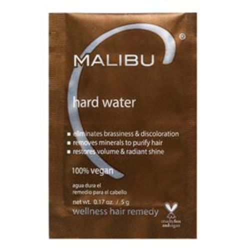 Sachet de cristaux Malibu C Hard Water Wellness – emballage blanc et orange posé sur fond blanc. Traitement capillaire anti-calcaire mono-dose pour cheveux exposés à l’eau dure. Végane, sans parfum ni sulfates.