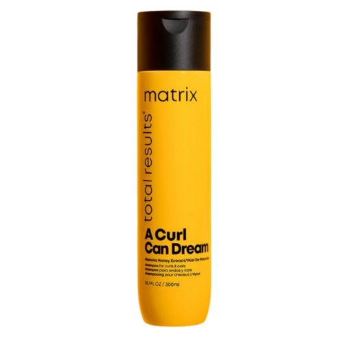 Bouteille jaune de 300 ml du shampoing Matrix A Curl Can Dream, formulé pour nettoyer en profondeur les cheveux frisés et bouclés sans compromettre leur forme naturelle. Enrichi en miel de Manuka.