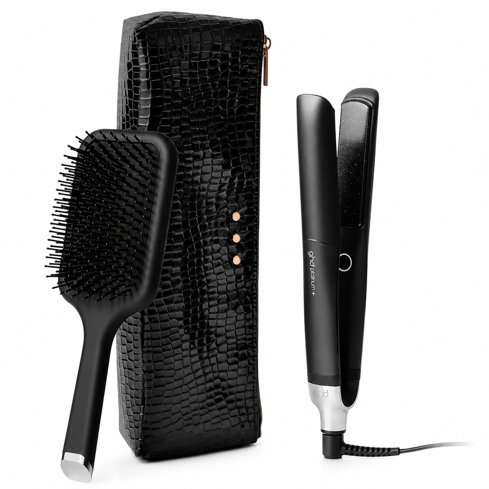 Trousse GHD Platinum+ comprenant un fer plat professionnel intelligent noir, une brosse plate GHD noire et un étui thermorésistant noir effet crocodile sur fond blanc.