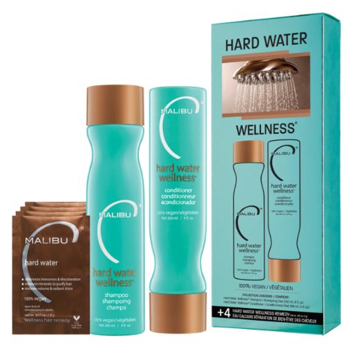 Ensemble Malibu C Eau Calcaire – bouteille de shampoing et revitalisant 266 ml avec étiquettes turquoise , accompagnés de 4 sachets Hard Water posés sur fond blanc. Routine capillaire végane contre les effets de l’eau dure.