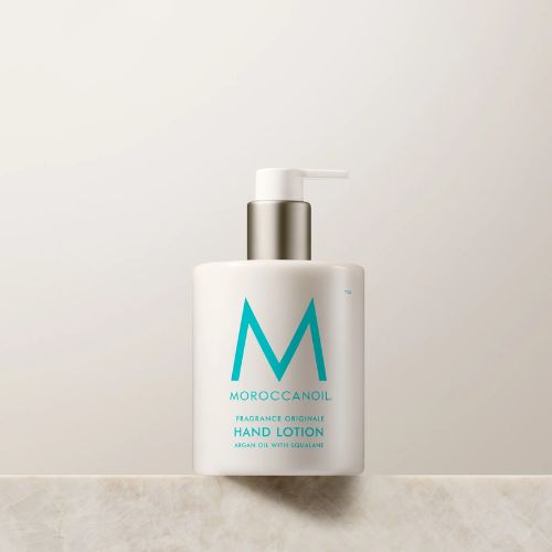 Flacon pompe de la crème hydratante mains Moroccanoil, texture légère et parfum signature.