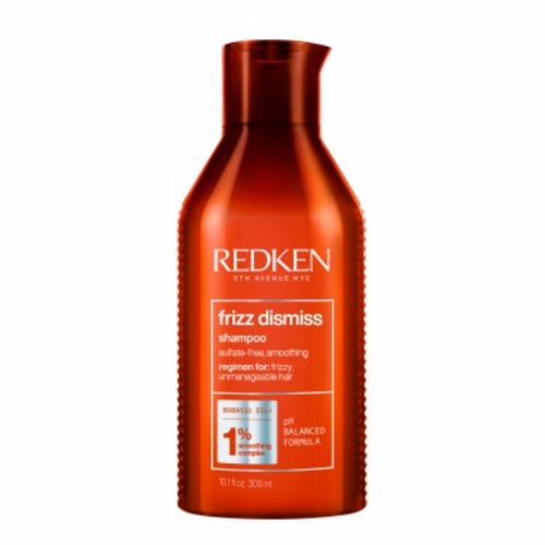 Bouteille orange REDKEN Frizz Dismiss shampoing lissant 300 ml avec bouchon flip-top, soin anti-frisottis pour cheveux secs et indisciplinés, fond blanc.