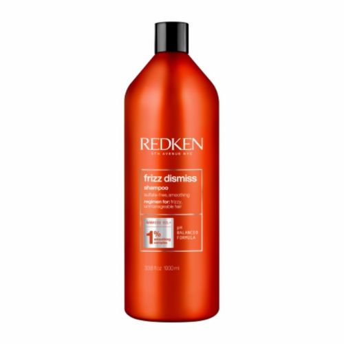 Grande bouteille orange REDKEN Frizz Dismiss shampoing lissant 1 litre avec bouchon noir, shampoing professionnel anti-frisottis pour cheveux rebelles, fond blanc.