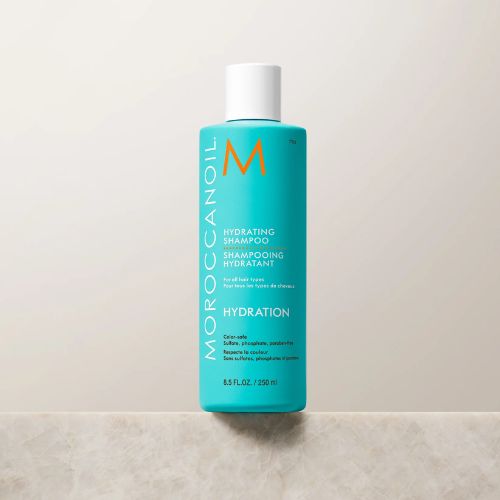 Flacon turquoise de 250 ml du shampoing hydratant Moroccanoil avec bouchon blanc, présenté sur fond blanc. Produit capillaire nourrissant à l’huile d’argan pour cheveux secs et colorés.