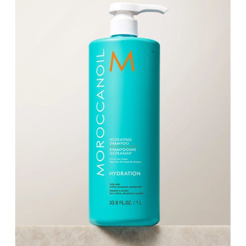 Bouteille turquoise de 1 litre du shampoing hydratant Moroccanoil avec pompe blanche, posée sur fond blanc. Soin capillaire professionnel à l’huile d’argan, conçu pour hydrater en profondeur les cheveux secs, naturels ou colorés. Idéal pour un usage fréquent ou en salon.