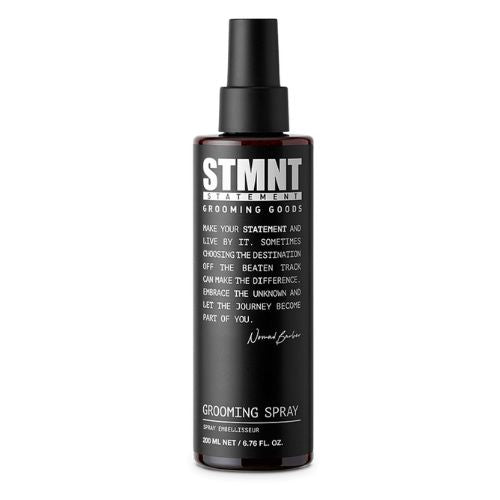Bouteille vaporisateur noire STMNT Grooming Spray coiffant texturisant de 200 ml avec fini professionnel sur fond blanc minimaliste.