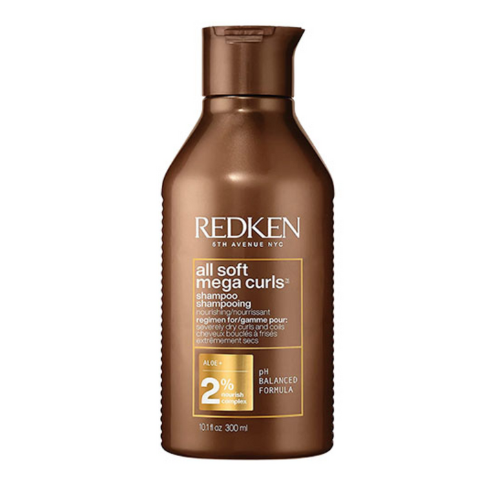 Flacon REDKEN All Soft Mega Curls shampoing 300 ml brun cuivre avec étiquette pour cheveux bouclés et très secs sur fond blanc.