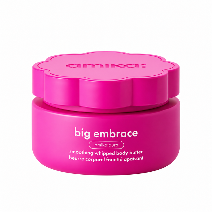 AMIKA Big Embrace beurre corporel fouetté apaisant, pot rose fuchsia avec couvercle fleur, présenté sur fond blanc