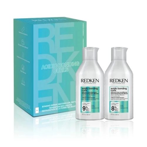 Coffret REDKEN Acidic Bonding Curls avec shampoing et revitalisant pour cheveux bouclés, bouteilles blanches avec étiquette  devant une boîte turquoise sur fond blanc.