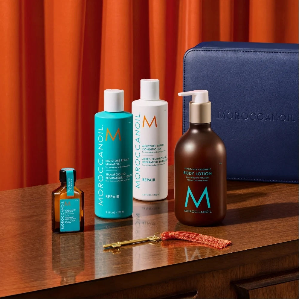 Coffret cadeau MOROCCANOIL The Repair Suite bleu marine avec quatre soins réparateurs et hydratants pour cheveux et corps.