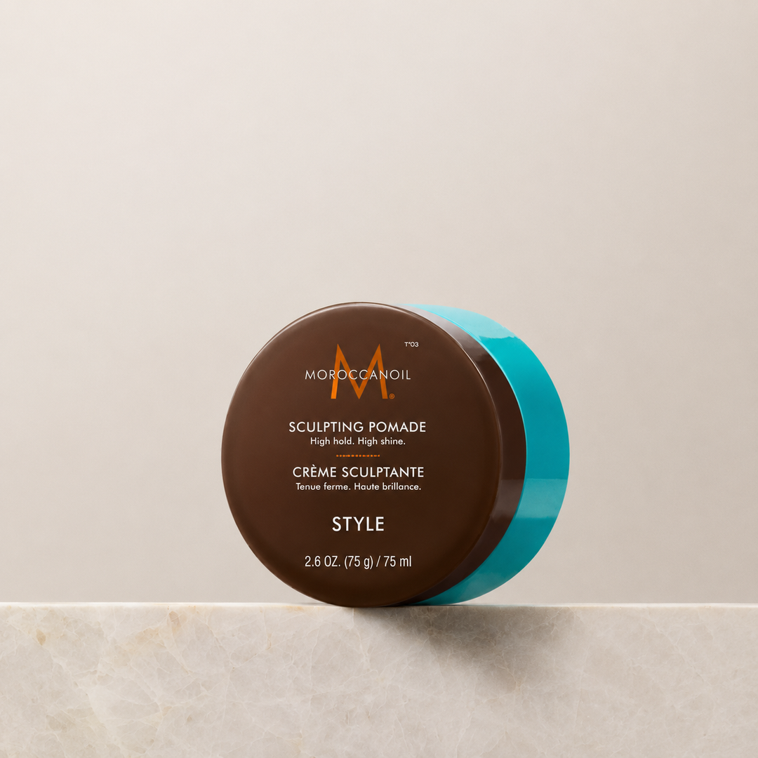 Crème Sculptante Moroccanoil 75 ml en pot brun avec couvercle turquoise, pommade coiffante professionnelle à tenue ferme et finition brillante sur fond beige.