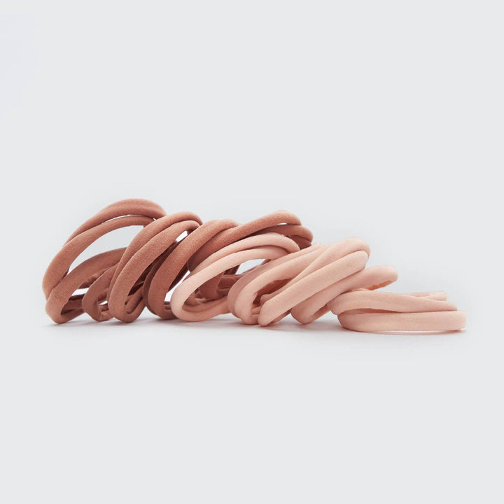 Élastiques KITSCH rose poudré et vieux rose en nylon recyclé disposés sur fond gris clair, accessoires cheveux doux sans couture pour tous types de cheveux.