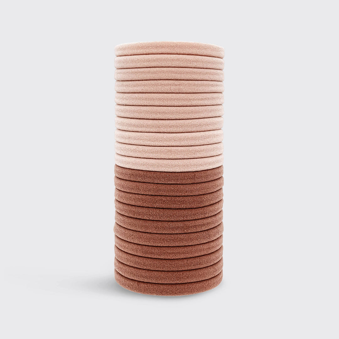 Élastiques KITSCH rose poudré et vieux rose en nylon recyclé disposés sur fond gris clair, accessoires cheveux doux sans couture pour tous types de cheveux.