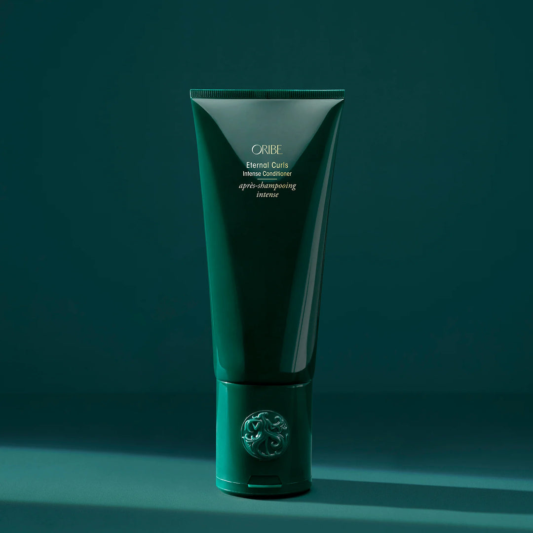 Après-shampooing intense Oribe Eternal Curls pour cheveux bouclés présenté en tube vert signature sur fond vert minimaliste.