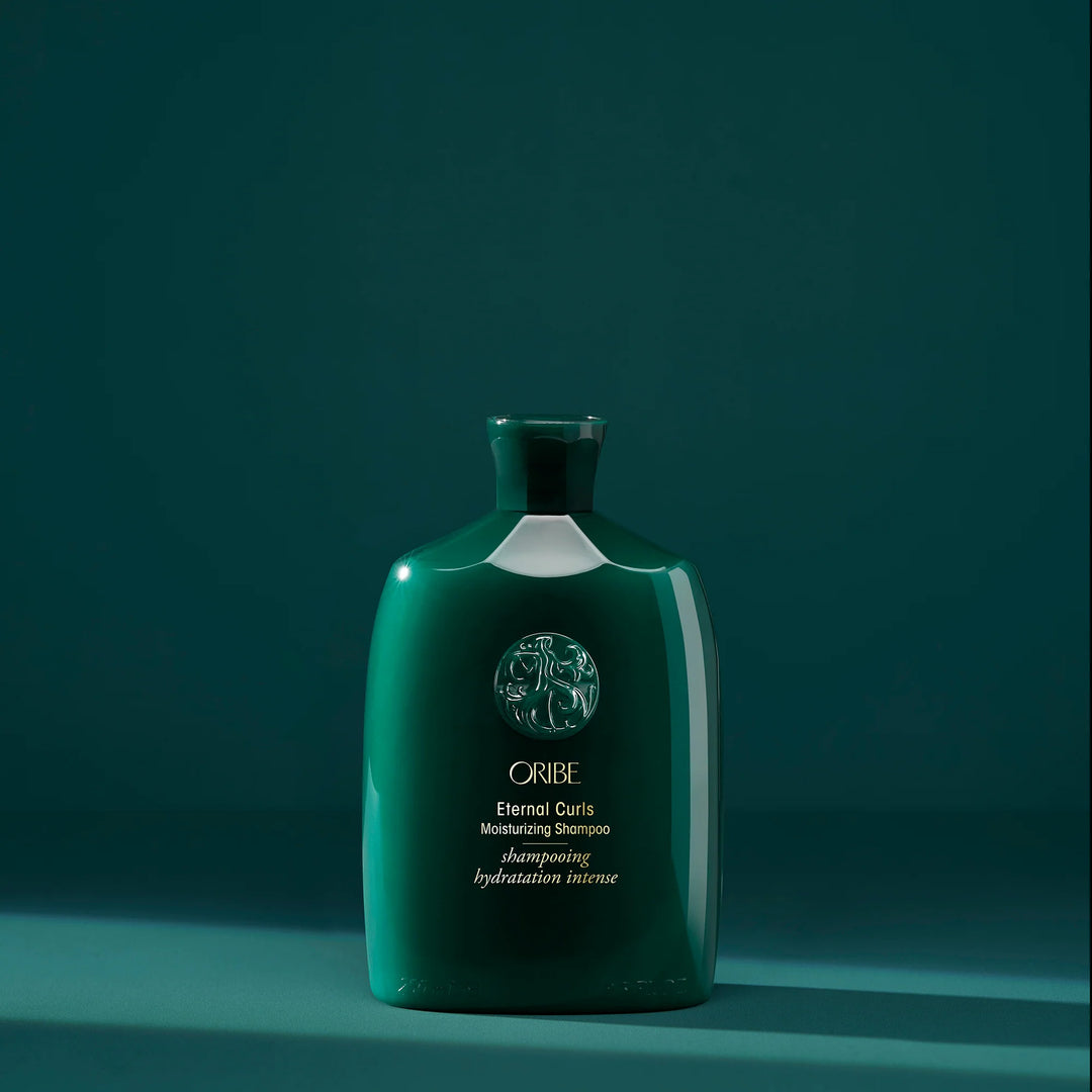 Shampooing hydratation intense Oribe Eternal Curls pour cheveux bouclés présenté en bouteille verte signature sur fond vert minimaliste.