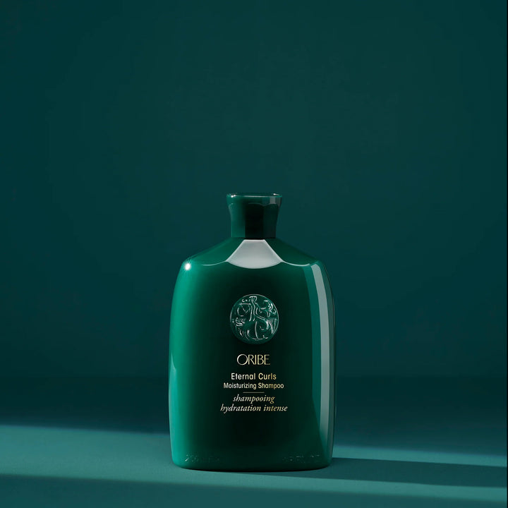 Shampooing hydratation intense Oribe Eternal Curls pour cheveux bouclés présenté en bouteille verte signature sur fond vert minimaliste.