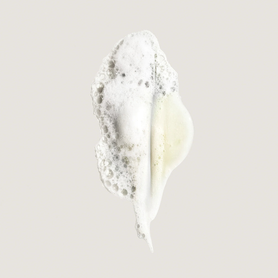 Texture mousseuse du shampooing hydratant Oribe Eternal Curls avec mousse aérienne et formule crémeuse conçue pour nettoyer et hydrater les cheveux bouclés.