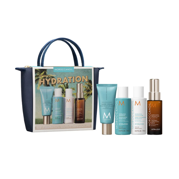 Coffret Moroccanoil Hydration dans une pochette bleu marin avec crème pour les mains, shampoing hydratant, revitalisant et traitement Moroccanoil présentés à droite sur fond blanc.