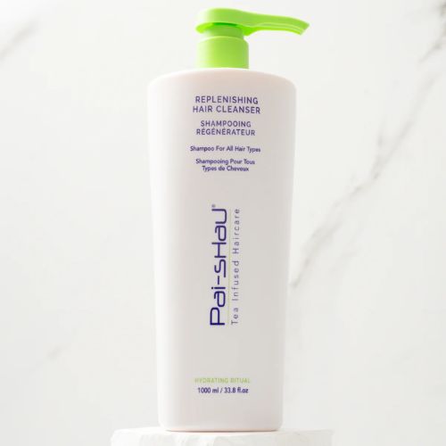 Grand flacon blanc mat de 1000 ml du Shampoing Régénérateur Pai-Shau avec pompe et bouchon vert lime, sur fond blanc. Shampoing végétalien hydratant pour cheveux colorés ou naturels, formule sans sulfate au thé infusé, beurre de karité et acides aminés.