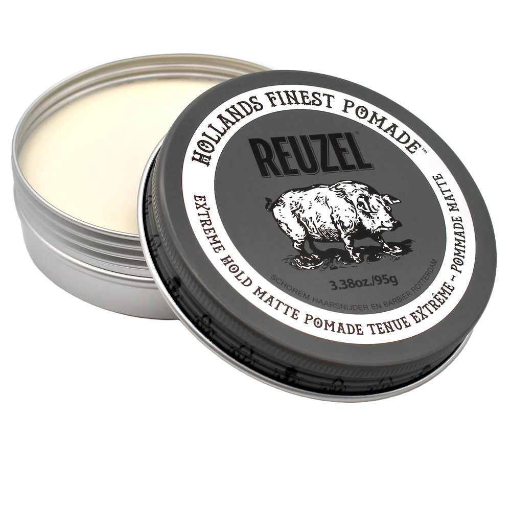 Pot métallique ouvert de pommade REUZEL Extreme Hold Matte 95 g avec texture claire visible et couvercle noir incliné, présenté sur fond transparent.