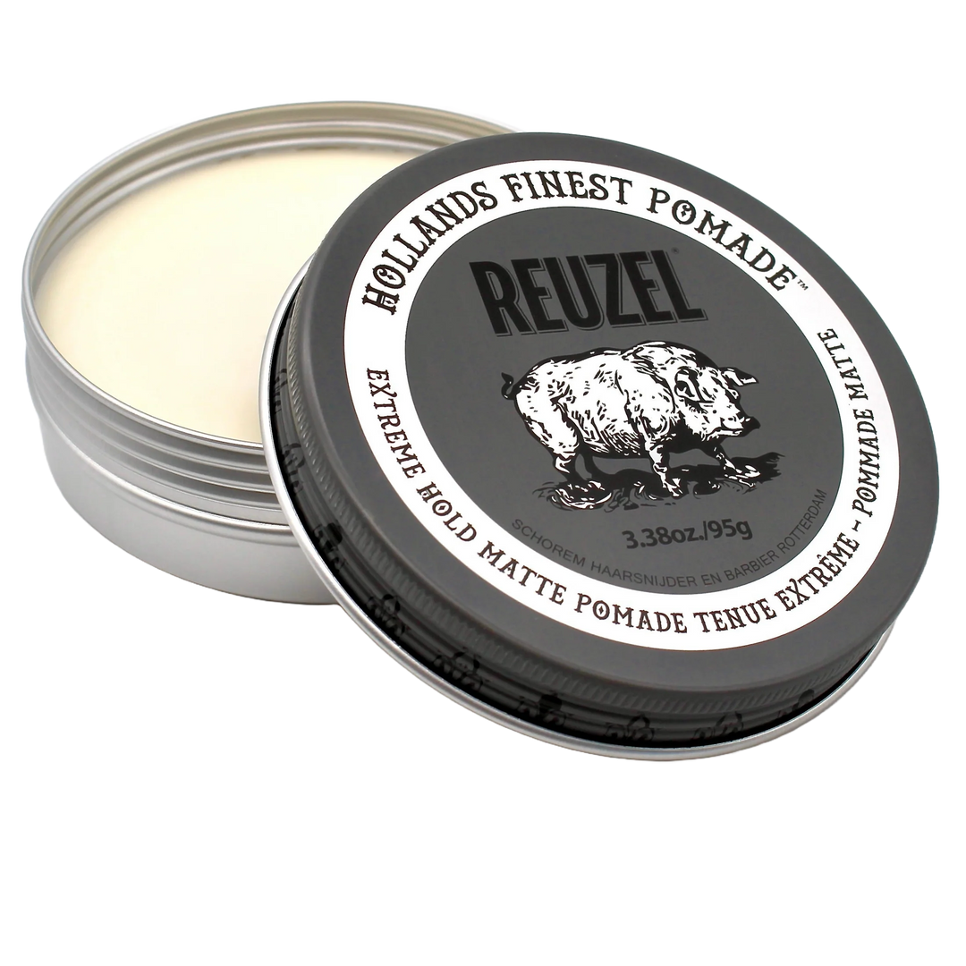 Pot métallique ouvert de pommade REUZEL Extreme Hold Matte 95 g avec texture claire visible et couvercle noir incliné, présenté sur fond transparent.