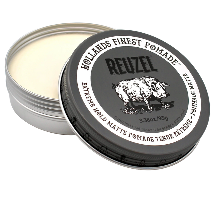 Pot métallique ouvert de pommade REUZEL Extreme Hold Matte 95 g avec texture claire visible et couvercle noir incliné, présenté sur fond transparent.