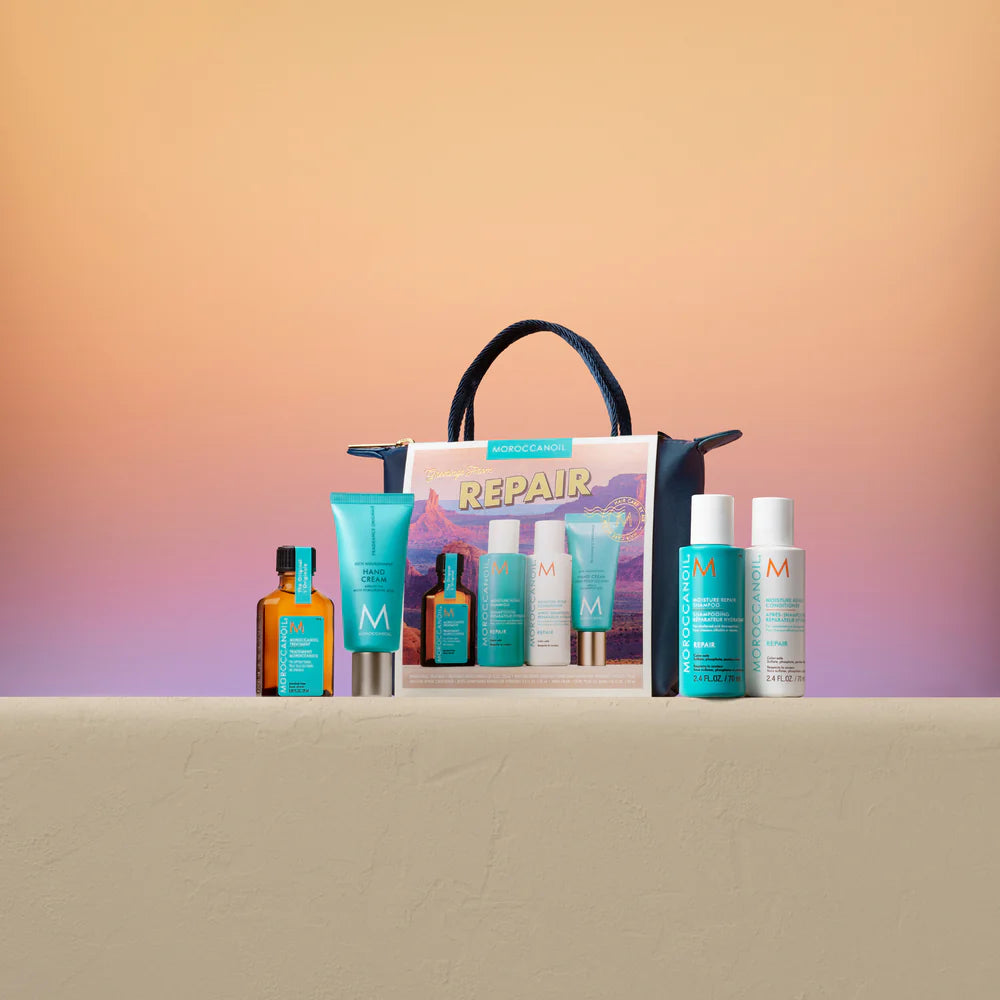 Produits Moroccanoil Repair alignés devant une pochette bleu marin sur fond dégradé orange et rose