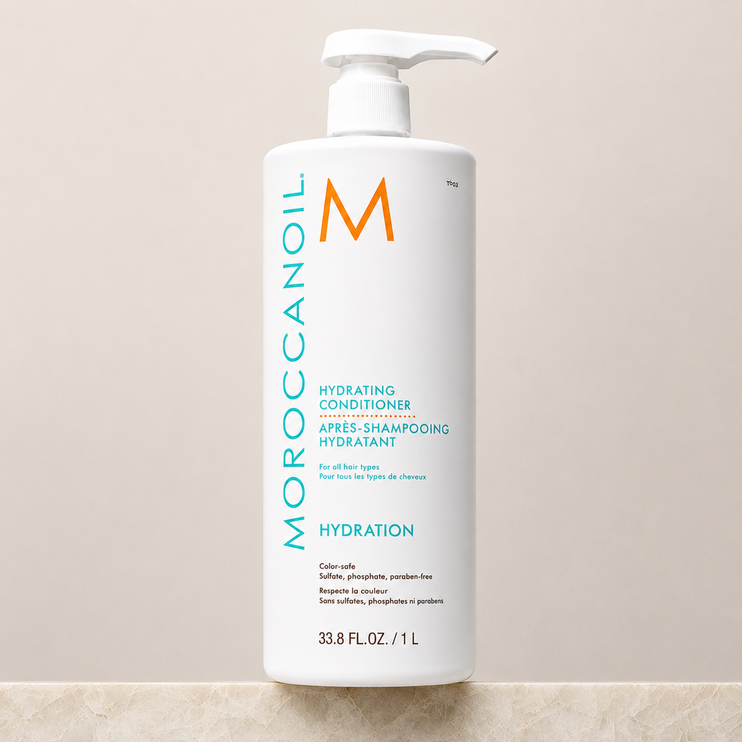 Après-shampoing hydratant Moroccanoil Hydration 1 litre avec pompe blanche, bouteille blanche grand format sur fond beige, image produit haute qualité optimisée SEO.
