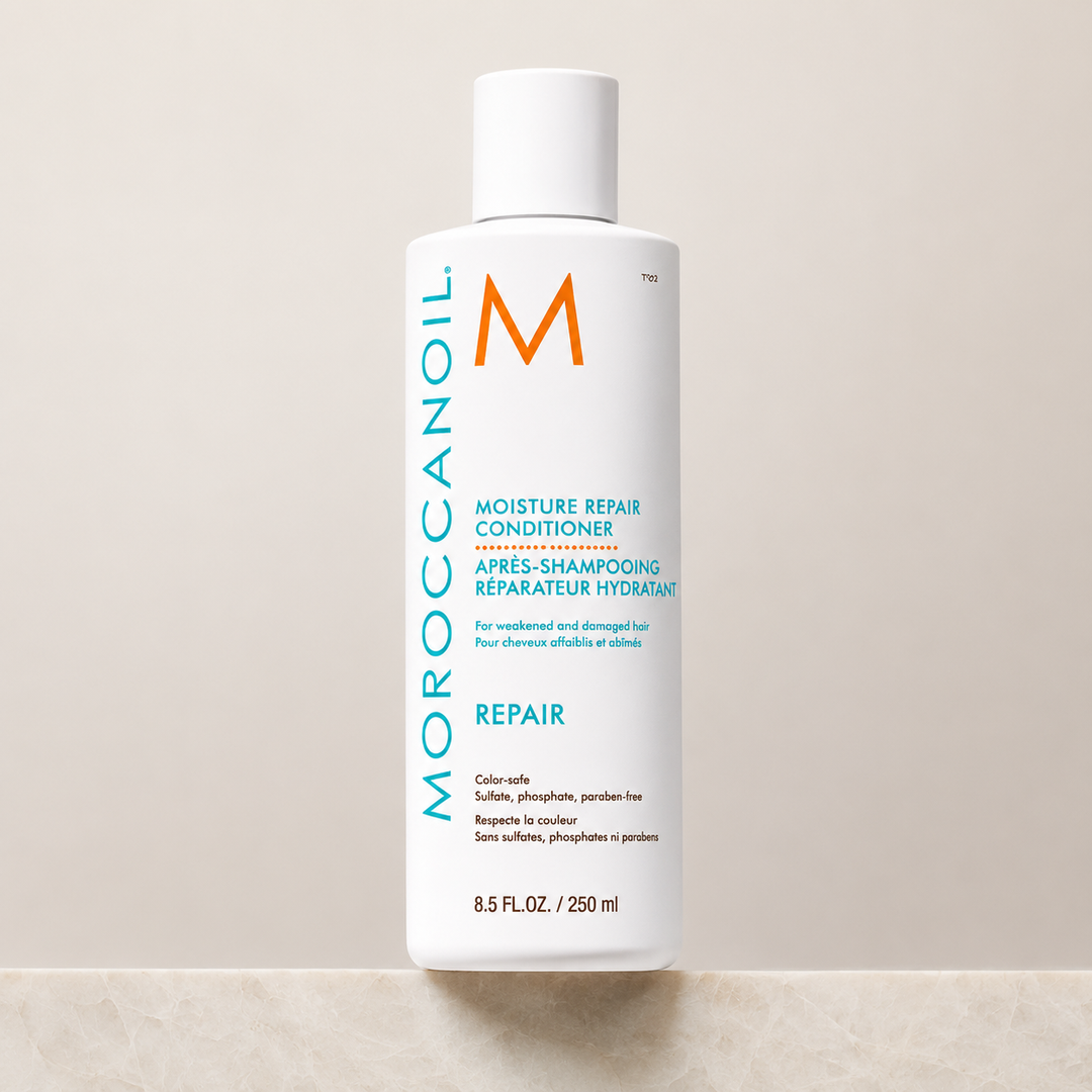 Après-shampoing réparateur hydratant Moroccanoil 250 ml en bouteille blanche avec bouchon blanc, étiquette turquoise et orange, présenté sur fond beige en studio.