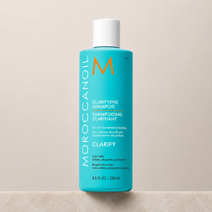 Shampoing clarifiant Moroccanoil 250 ml en bouteille turquoise avec bouchon blanc, présenté sur un fond beige minimaliste. Soin nettoyant profond pour éliminer les résidus, le sébum et les impuretés, idéal pour tous les types de cheveux.