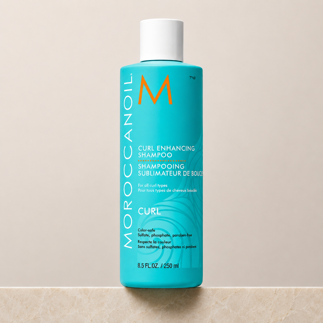 Shampoing Sublimateur de Boucles Moroccanoil 250 ml en bouteille turquoise avec bouchon blanc, fond beige minimaliste, photo produit professionnelle pour cheveux bouclés.