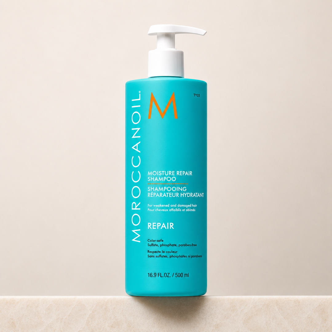 Bouteille turquoise Moroccanoil Shampoing Réparateur Hydratant avec bouchon blanc, format 500 ml, présentée sur fond beige clair. Soin capillaire réparateur à l’huile d’argan pour cheveux abîmés.