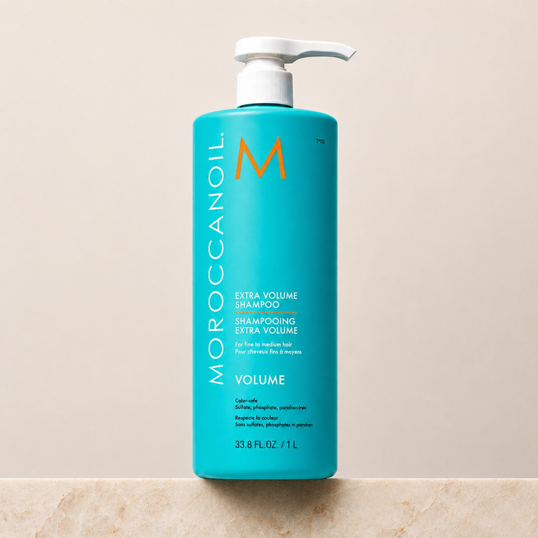 Shampoing Extra Volume Moroccanoil  1 L en bouteille turquoise avec bouchon blanc ou pompe blanche, étiquette blanche et orange, photo professionnelle sur fond beige, soin volumisant pour cheveux fins