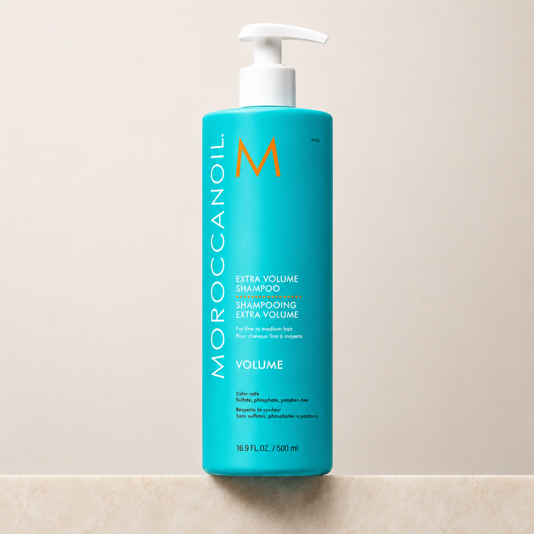 Shampoing Extra Volume Moroccanoil 500 ml en bouteille turquoise avec bouchon blanc ou pompe blanche, étiquette blanche et orange, photo professionnelle sur fond beige, soin volumisant pour cheveux fins